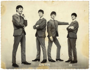 PH11. An Iconic Dezo Hoffmann 'Standing Collarless Suits' Photograph Signed On The Back By The Beatles